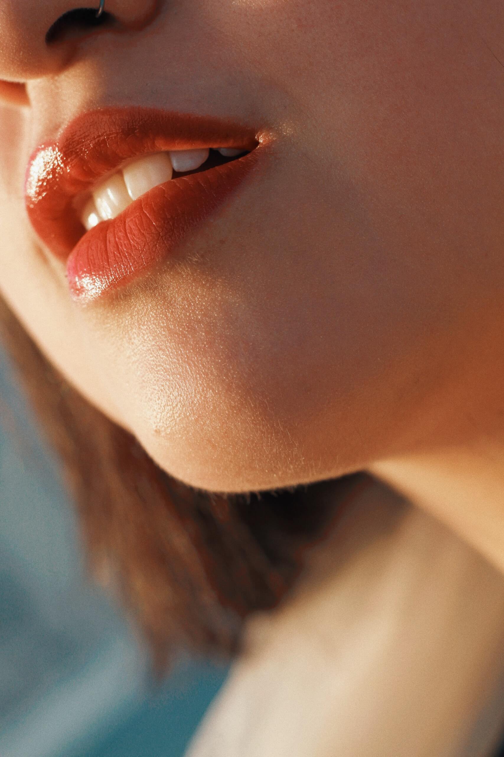 Close-up photography of a young woman with defined red lips and white teeth
