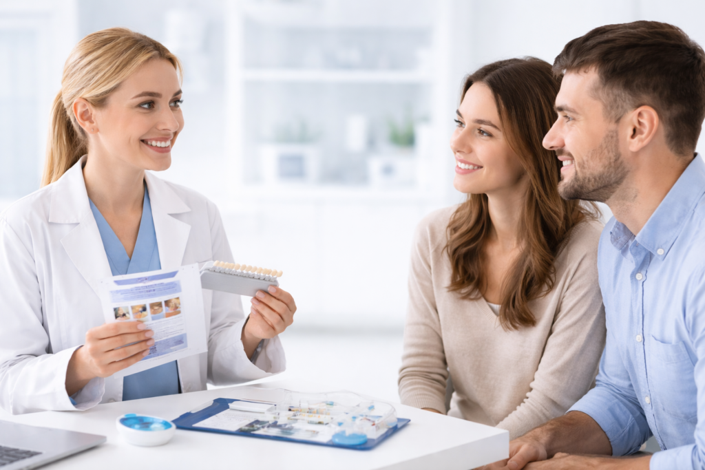 Dentist discussing teeth whitening options with a couple during a professional consultation